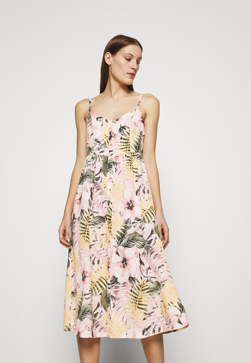 Blumenkleid mit pinkem Hintergrund und gelben sowie grünen tropischen Blättern, dünnen Trägern, einer taillierten Passform und Knopfdetails.
