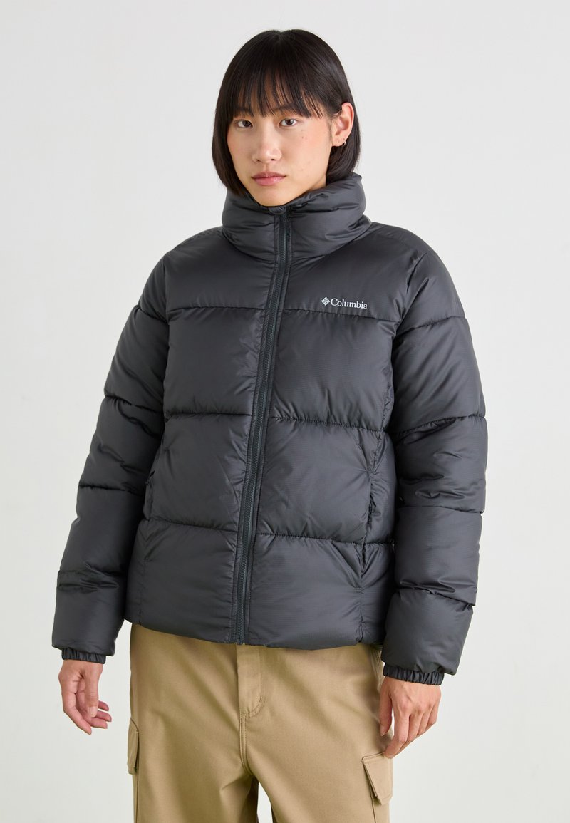 Zwarte pufferjacket met een hoge kraag, horizontale gestikte ontwerp en ritssluiting aan de voorkant. Bevat het Columbia-logo op de borst.