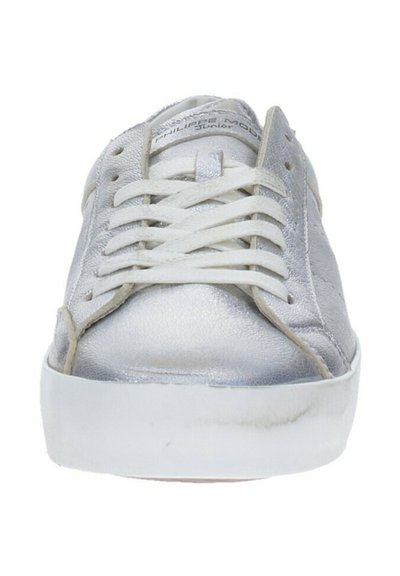 Sneaker metallici argento con una superficie liscia, lacci bianchi e suola in gomma bianca. Presentano cuciture minime e un logo sulla linguetta.