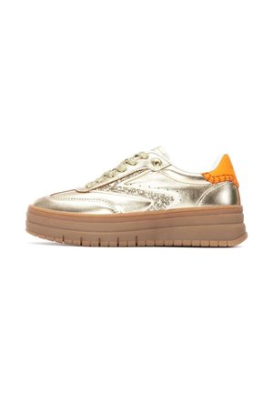 Zapatillas metálicas doradas con un acabado brillante, acentos texturizados, talón naranja y suela de goma gruesa. Presentan un cierre con cordones y un diseño de corte bajo.