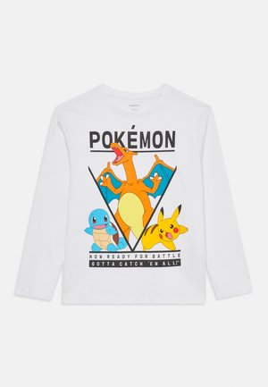 Maglietta bianca a maniche lunghe con personaggi dei Pokémon: Charizard, Squirtle e Pikachu con il testo "ORA PRONTI PER LA BATTAGLIA DEVI CATTURARLI TUTTI!"