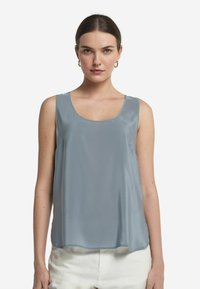 Ljusblå ärmlös topp i slät tyg med rund halsringning och avslappnad passform, med tunna axelband och utan synliga mönster.
