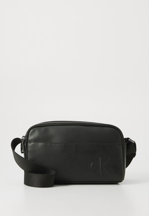 Zwarte leren tas met ritssluiting, verstelbare schouderband en geperst logo. Rechthoekige vorm, gladde textuur, minimalistisch ontwerp.