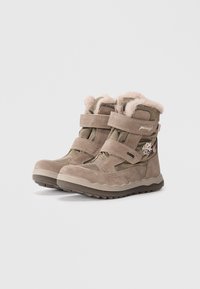 Bottines tan avec doublure en fausse fourrure, deux sangles velcro réglables, dessus en suède texturé et nylon, et semelle en caoutchouc avec motif en zigzag.