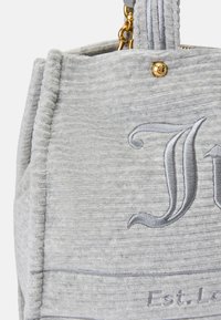 Bolsa de tecido cinza texturizado com iniciais bordadas em cinza claro, ferragens douradas, fecho de zíper e bordas reforçadas com costura.