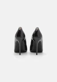 Leren zwarte high-heeled schoenen van lakleer met een spitse neus, slanke silhouette en een gouden accent aan de achterkant. Glad van structuur.