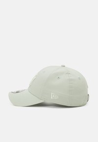 Hellgrüner Baseballcap mit gebogenem Schirm, versehen mit bestickten Logos und Belüftungslöchern auf der Krone. Strukturierte Stoffoberfläche.