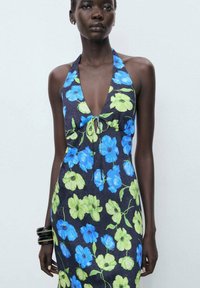 Floral dress featuring a dark background with blue and green flowers, halter neck design, tie detail at the front, and fitted silhouette.