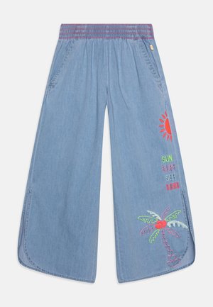 Lyseblå vidde bukser med elastisk talje, sideslidser og farverigt broderi med sol, palme og ordene sol, surf, hav, sand på højre ben.