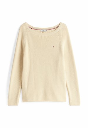 Crème-kleurige sweater met een brede halslijn, geribbelde structuur en lange mouwen; heeft een klein logo geborduurd op de borst.