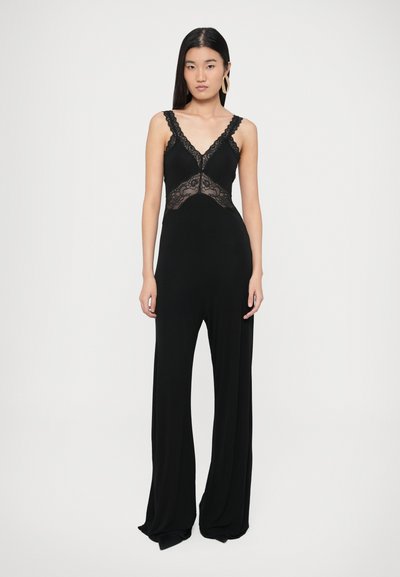 Czarny kombinezon z koronkowymi zdobieniami na gorsecie, z szerokimi nogawkami i regulowanymi ramiączkami. Miękka, gładka tkanina o dopasowanym kroju.