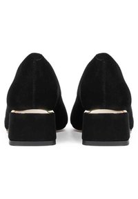 Scarpe nere in suede con tacco a blocco e punta affusolata. I tacchi sono corti e robusti, caratterizzati da una superficie liscia e da decorazioni minime.