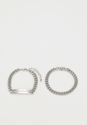 Zilveren kettingarmbanden met een platte staaf met gegraveerde tekst, één met een karabijnsluiting en een verstelbare verlengketting.