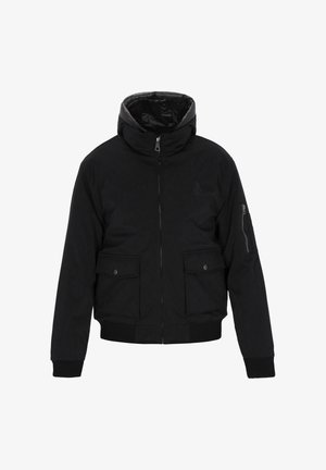 Giacca isolata nera con colletto alto, chiusura con zip, due tasche frontali e tessuto testurizzato. Accentuata da un logo sul petto.