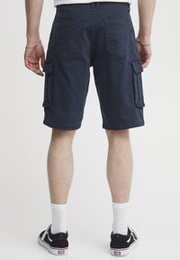 Marineblå cargo shorts laget av bomull med flere lommer, sydd detaljer og en avslappet passform, med en hemmet beinlengde som ender over kneet.