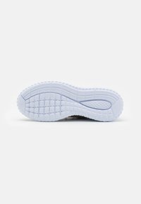 Semelle de chaussure en caoutchouc blanc avec des motifs de grip texturé ; forme incurvée avec des bords arrondis et une légère indentation au niveau du talon.