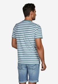 Heren T-shirt met korte mouwen in teal en witte horizontale strepen, ronde halslijn en zachte stof, gecombineerd met opgerolde denim shorts.