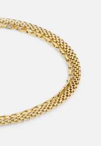 Collana in oro con design intrecciato, composta da anelli quadrati piatti, finitura testurizzata e tre filamenti paralleli che si sovrappongono.