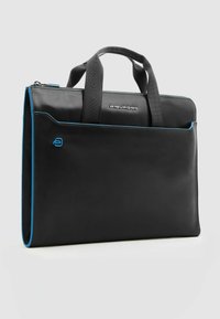Bolso para portátil de cuero negro con detalles en azul, con dos asas resistentes y un bolsillo delantero. Diseño delgado adecuado para uso profesional.