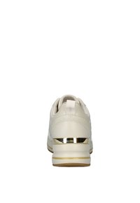 Zapatilla blanca de piel con acento metálico dorado en el talón, que presenta una textura suave y una ligera curvatura en su diseño.