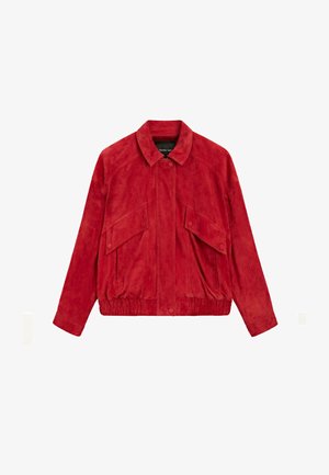 Giacca in camoscio rossa con tasche anteriori con patta, chiusura con bottoni automatici, orlo elastico e collo classico, distesa su sfondo bianco.