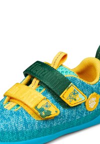 Scarpa texturizzata blu e verde con cinturini gialli, caratterizzata da una grafica di un orso. Chiusure in velcro e colletto imbottito per il comfort.