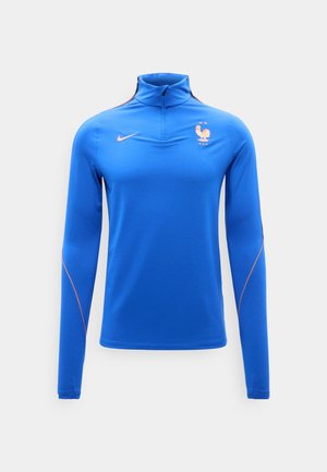 Sinine pikkade varrukatega spordipluus kvartzipuga, millel on kuldne Nike’i logoga ja Prantsuse jalgpalliföderatsiooni kukelogo kahe võimalusega rinnal.