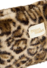 Tela de pelaje sintético con estampado de leopardo, con una etiqueta rectangular cosida que dice "grain de malice" en texto marrón claro.