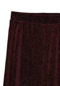 Jupe en velours bordeaux avec un motif texturé de petits carrés, dotée d'une large taille et d'un design fluide. Fini de surface lisse.