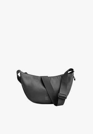 Sac bandoulière gris en matériau lisse, avec une forme incurvée, une sangle réglable et un logo sur le devant.