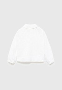 Cămașă albă scurtă cu o textură moale, mâneci lungi cu manșete elastice și un guler clasic. Design simplu, fără modele vizibile sau accesorii.