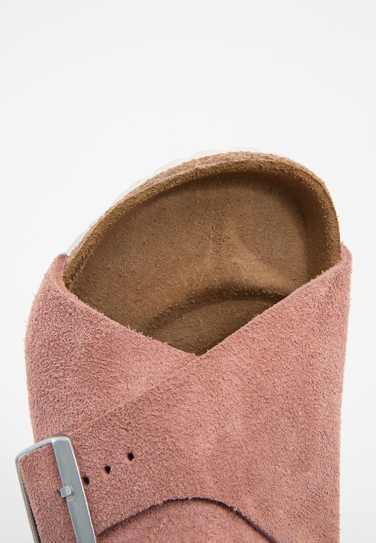 Rosa Wildledersandale mit einem breiten Kreuzriemen-Design, ergänzt durch eine silberfarbene Schnalle und einer strukturierten braunen Innensohle.