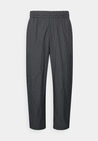 Svart-vita rutiga byxor med resårmidja, som har en avslappnad passform och avsmalnande ben, tillverkade av lätt tyg.