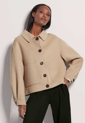 Beige wollenmix jack met kraag, grote buitenzakken en donkere knopen. Kenmerkt losse mouwen en een cropped ontwerp.