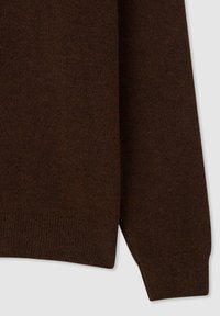 Maglione a maglia marrone con una texture liscia, polsini e orlo a costine, e una silhouette rilassata con dettagli di cuciture minimi.