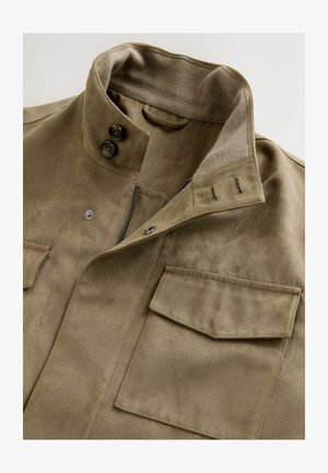 Veste en suède marron avec un col montant, deux poches avant et une fermeture éclair. Le tissu a une finition douce et texturée.