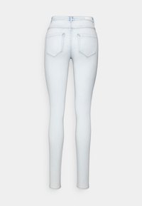 Jeans ajustados de color azul claro con cintura alta, que cuentan con dos bolsillos traseros, una textura suave y detalles de costura mínimos.