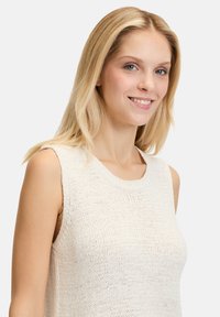 Top senza maniche lavorato a maglia di colore crema, con scollatura rotonda e tessuto strutturato. Design semplice con vestibilità rilassata e senza motivi visibili.