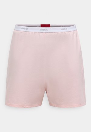Shorts rose clair en tissu doux, dotés d'une ceinture élastique blanche avec le logo "HUGO". Coupe droite sans poches ni détails supplémentaires.