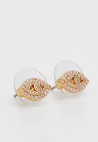 Aukso spalvos auskarai, suformuoti kaip akys, su skaidriais laikikliais ir puošti blizgančiais rhinestones aplink centrinį brangakmenį.