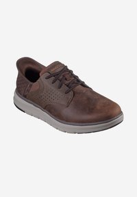 Brune lædersneaker med grå gummisål. Har snørebåndsdesign, perforerede accenter og struktureret hælpatch. Designet til komfort.