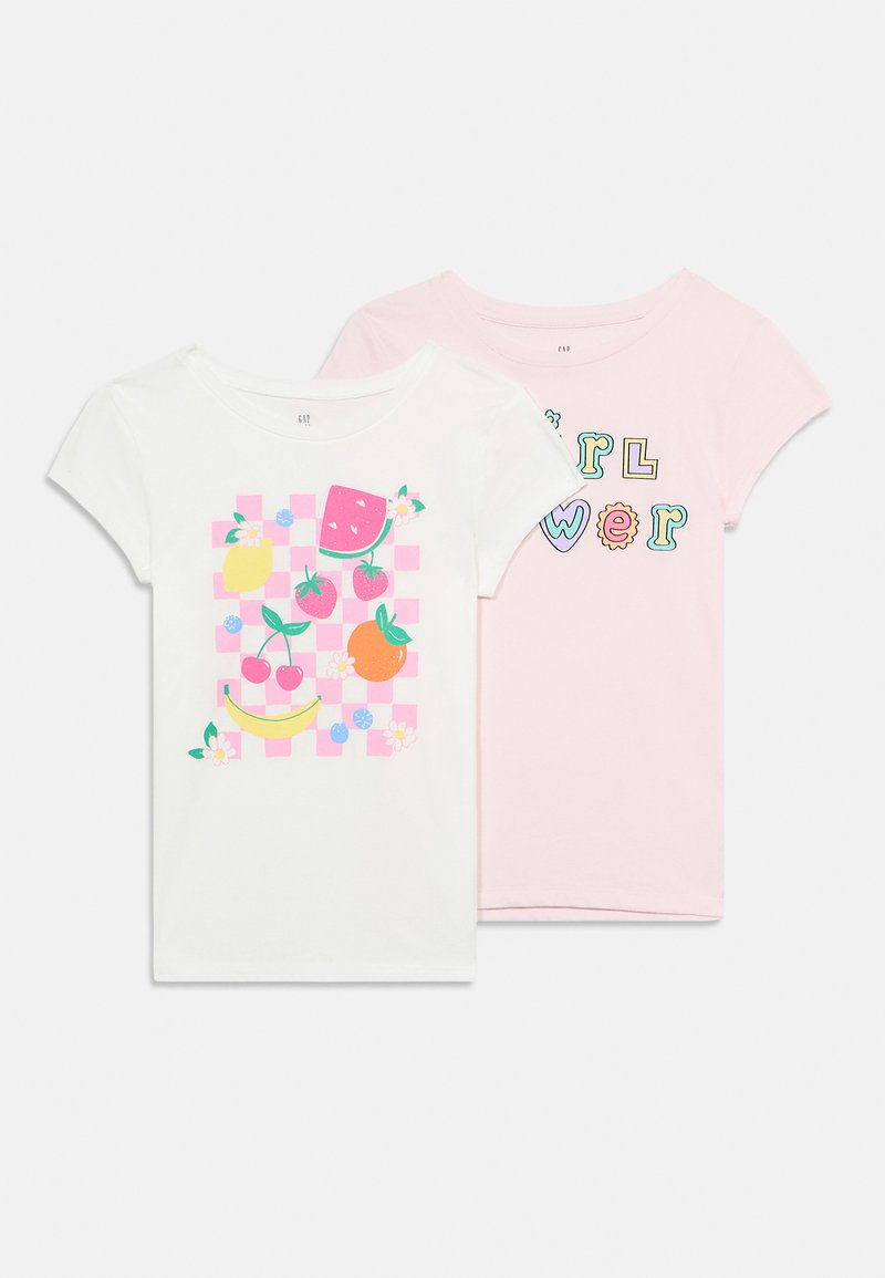 Δύο κοντομάνικα παιδικά μπλουζάκια, ένα λευκό με πολύχρωμο σχέδιο φρούτων και ένα ροζ με το κείμενο «girl power» σε παιχνιδιάρες γραμματοσειρές.