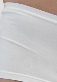 Weiße Baumwollshorts mit glatter Textur, ausgestattet mit einem umgeschlagenen Bund und dezenten Nahtdetails. Schlichtes und minimalistisches Design.