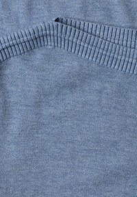 Pull tricoté bleu clair plié montrant un col côtelé et une texture fine.
