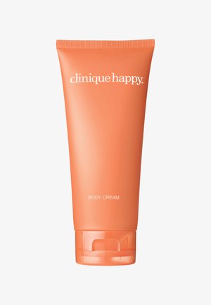 Orange plastikrør med Clinique Happy body cream; har et flip-top låg, hvide tekst og en glat mat finish.
