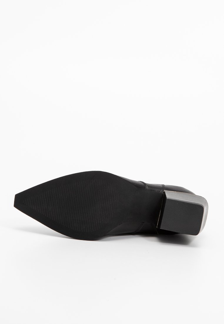 Stivale alla caviglia nero con tacco, dalla punta affusolata e suola in gomma strutturata, dotato di un tacco a blocco e un design geometrico elegante.