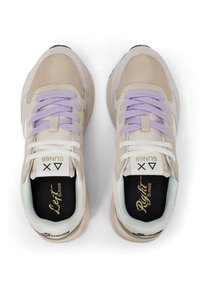 Scarpe da ginnastica beige in materiali mesh e suede, con lacci lavanda e soletta nera contrastante etichettata "Sinistra" e "Destra".