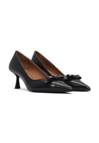 Black leather high-heeled pumps with a pointed toe and a small bow accent on the front. The texture is smooth with a polished finish.