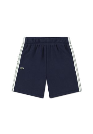 Pantaloncini sportivi blu navy con fascia elastica in vita, strisce laterali bianche con scritta ripetuta "LACOSTE" e piccolo logo verde del coccodrillo sulla gamba sinistra.