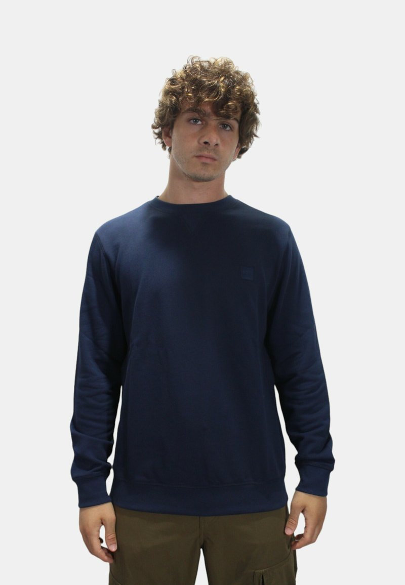 Felpa blu navy realizzata in tessuto morbido con scollo a girocollo e polsini a costine. Presenta un piccolo logo testurizzato sul davanti.